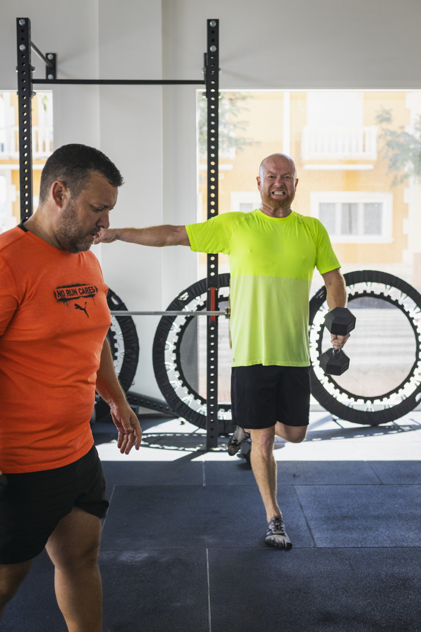 Entrenamiento funcional de equilibrio y fuerza con mancuernas en gimnasio. Persona realizando ejercicio de estabilidad para cintura y espalda.